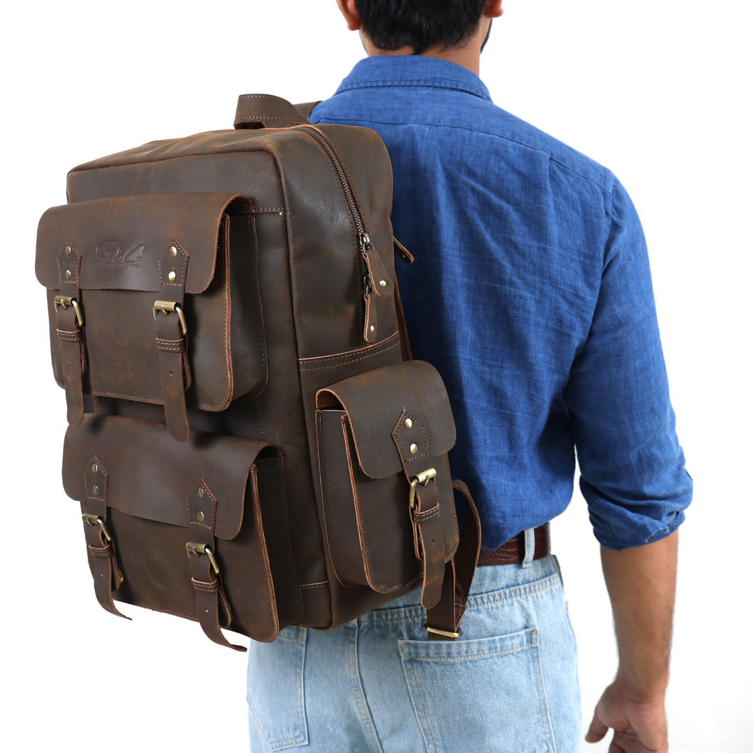 Person wearing a large brown leather backpack on a white background