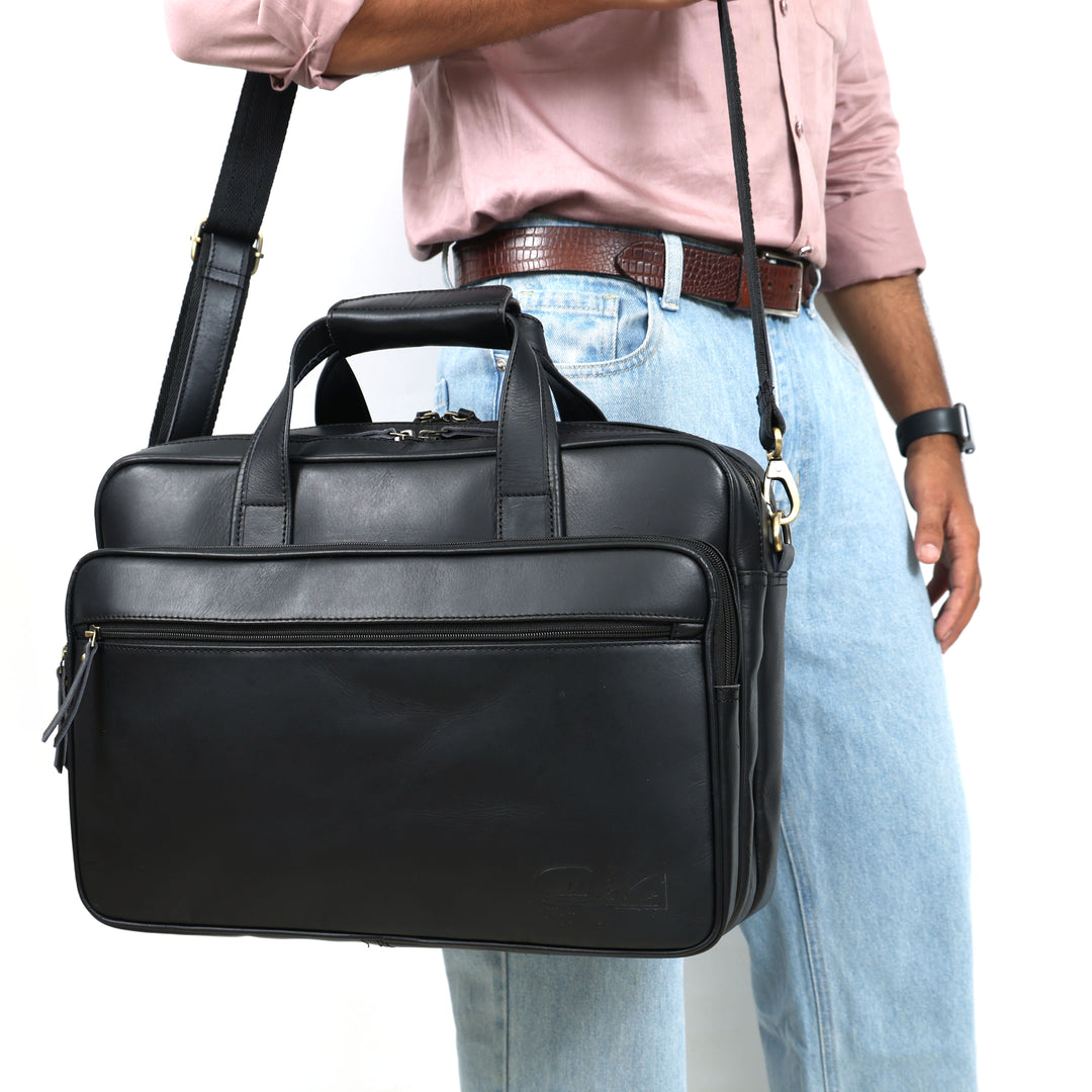 Person holding a black leather briefcase with a white background