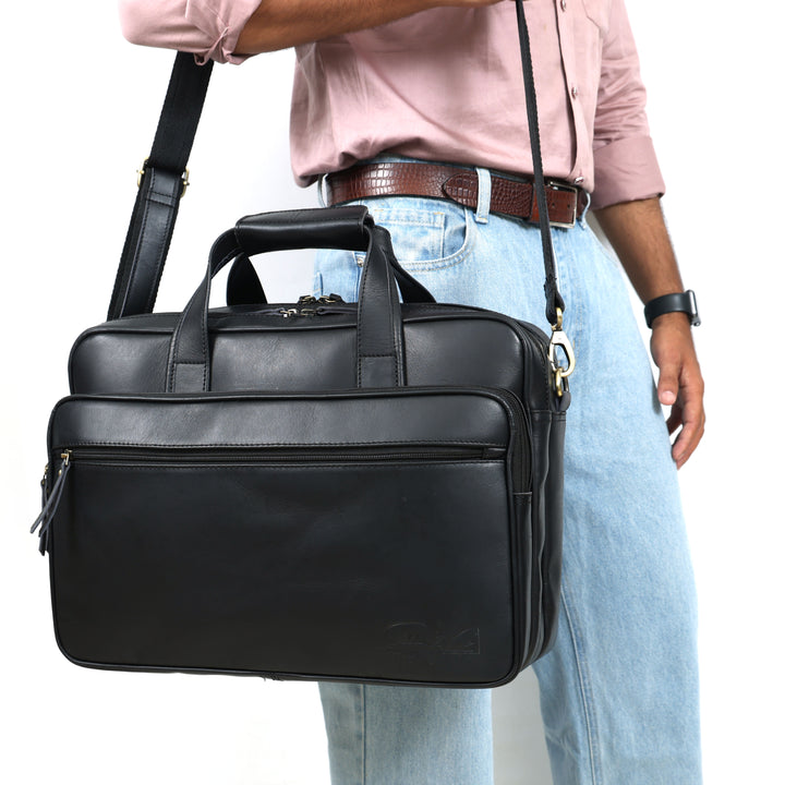 Person holding a black leather briefcase with a white background