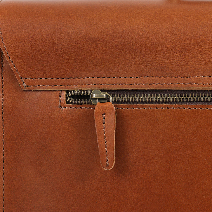 Close-up of a brown leather bag with a zipper