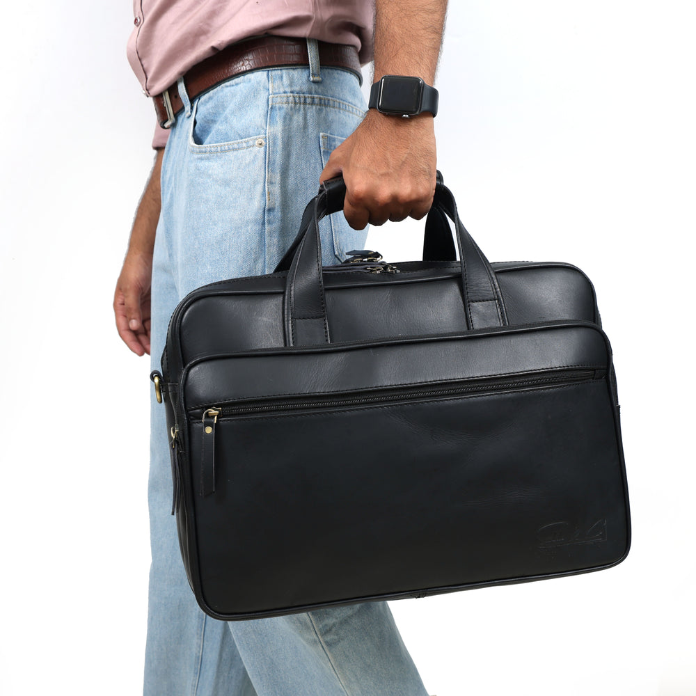 Person holding a black leather briefcase against a white background