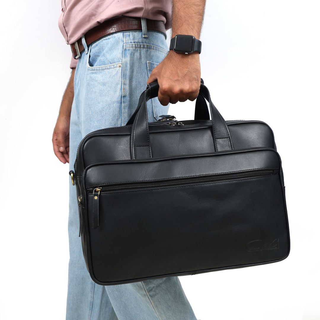 Person holding a black leather briefcase against a white background
