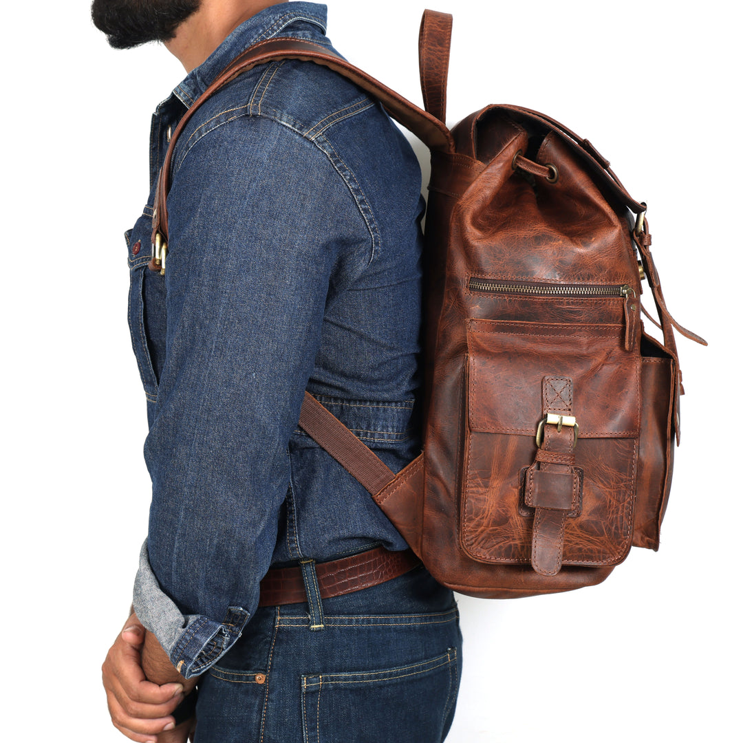 Person wearing a brown leather backpack on a white background