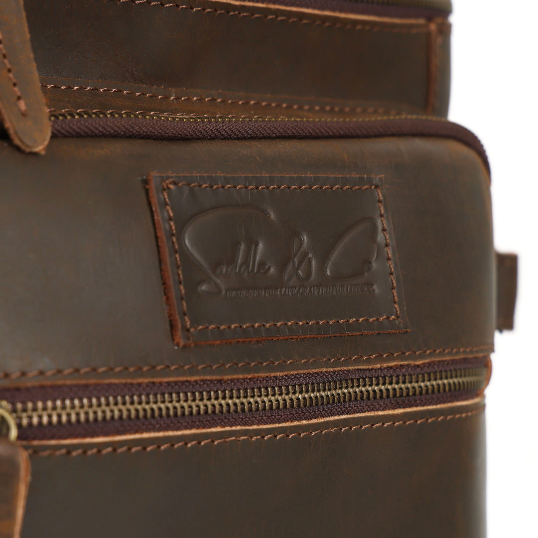 Close-up of a brown leather bag with a brand logo on a white background