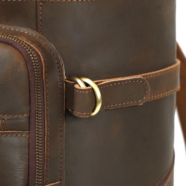 Close-up of a brown leather bag with a gold buckle on a white background