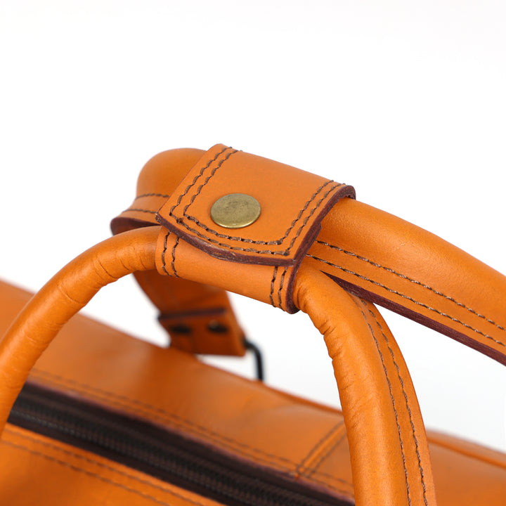 Close-up of an orange leather bag handle with stitching detail on a white background