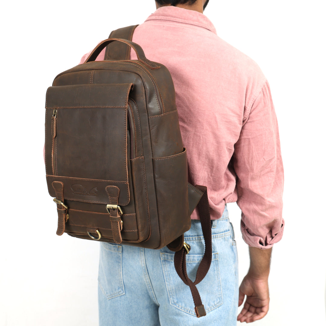 Person wearing a brown leather backpack on a white background